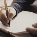 Someone writing in a notebook