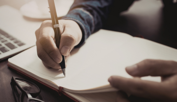 Someone writing in a notebook