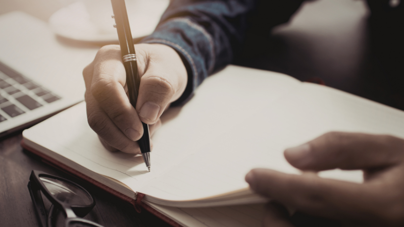 Someone writing in a notebook