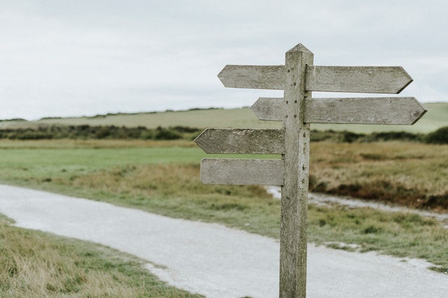 Wooden signpost with different arrows