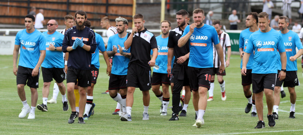 Toby walking with football players