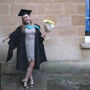 Picture of Hazel in her graduation gown holding some flowers