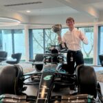 A photo of Sam Snudden standing next to an F1 car