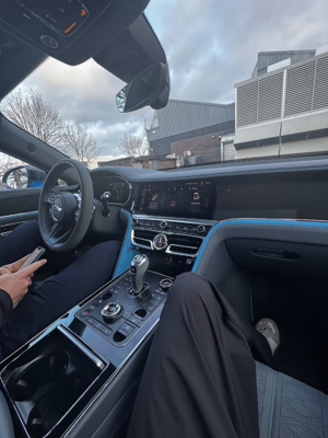 Shyan demonstrating the wood and leather inside a Bentley interior