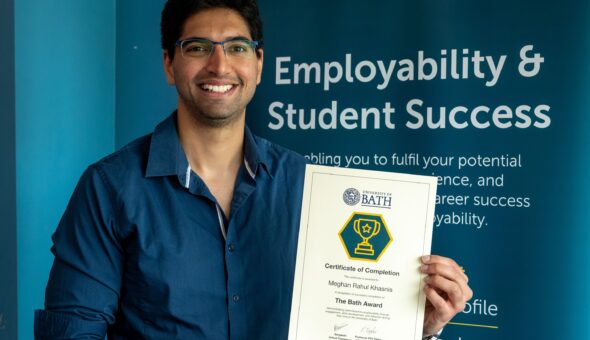 A photo of Meghan Khasnis with his Bath Award certificate