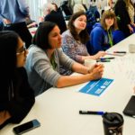 Colleagues sat in a row on a table with paperwork