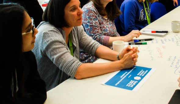Colleagues sat in a row on a table with paperwork