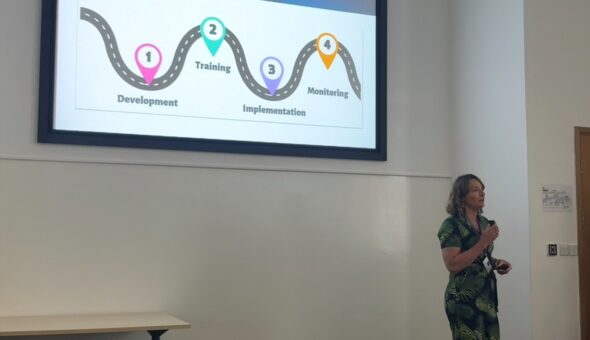 Person presenting in front of a conference screen