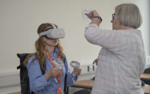 Participant with VR Headset on and colleague back of head directing them