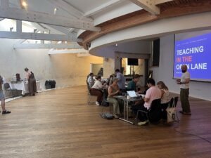 Participants working together at tables in curved shaped room