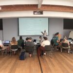 Whiteboard and speaker facing room, participants facing whiteboard