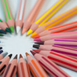 Coloured pencils arranged in a circle with their leads pointing in towards the centre.