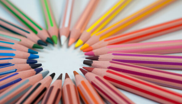 Coloured pencils arranged in a circle with their leads pointing in towards the centre.