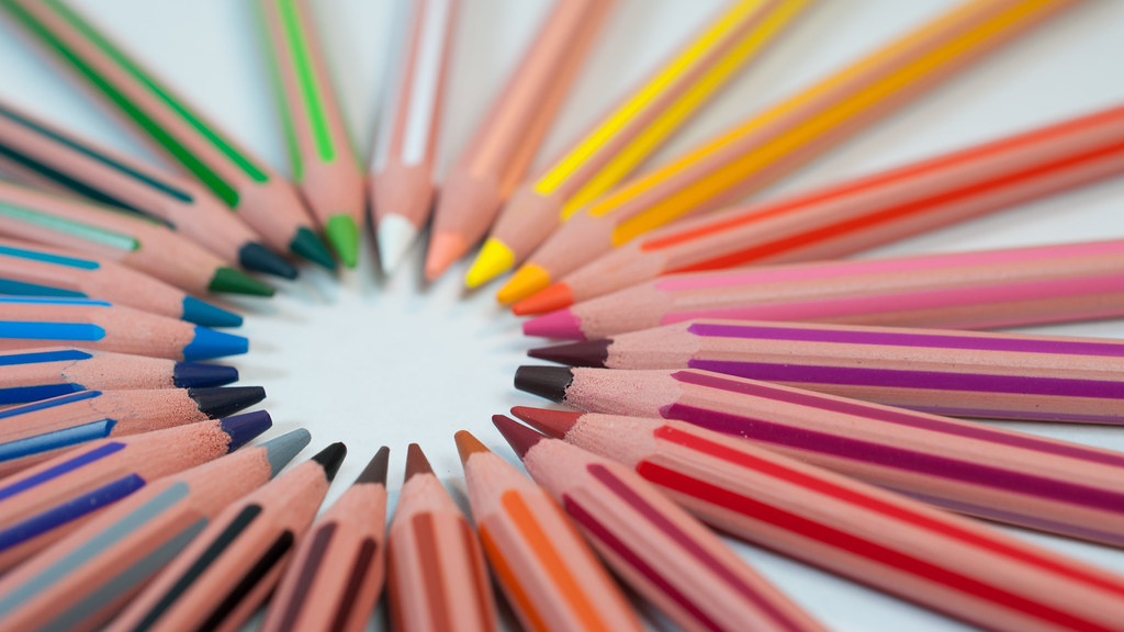 Coloured pencils arranged in a circle with their leads pointing in towards the centre.