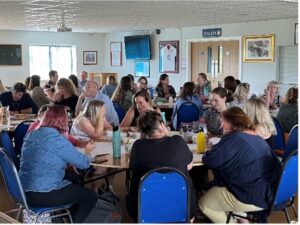 Groups of people sat around tables at an event