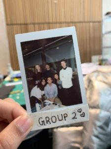 A hand holds a Polaroid of the team members