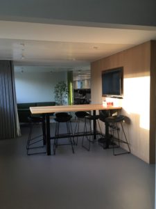 A common room with a table and several high chairs