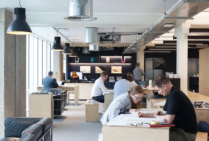 People working in a spacious, indoor common space