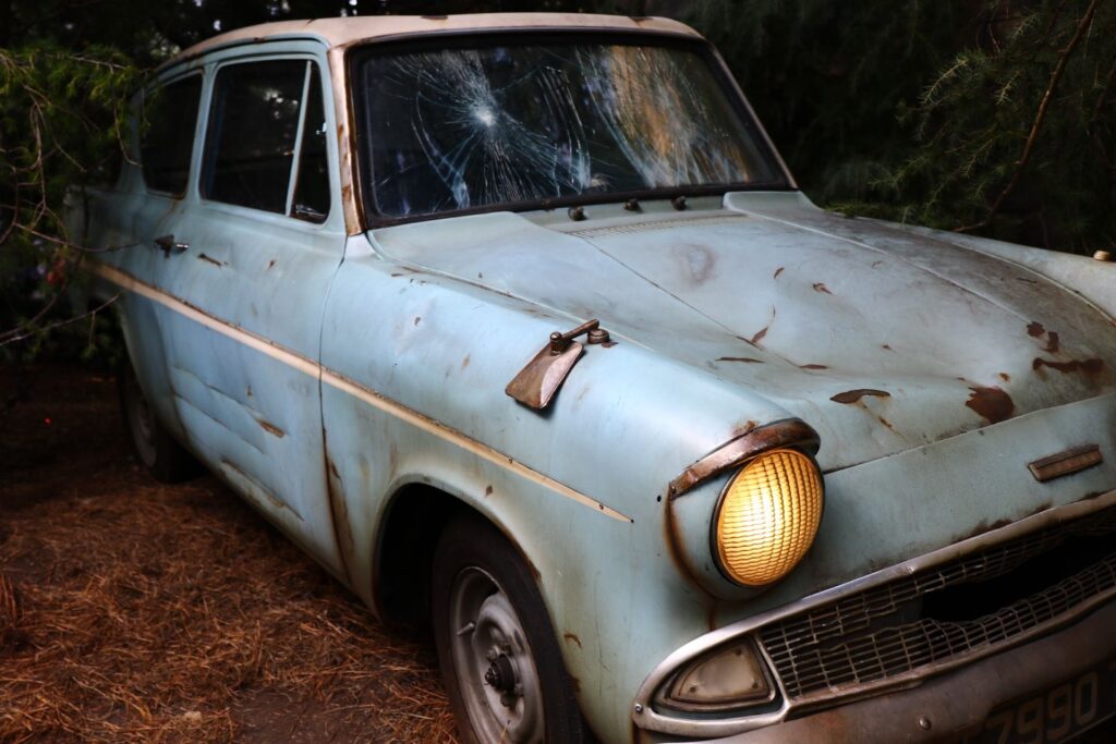 image of battered light blue Ford Anglia with lights on from Harry Potter.