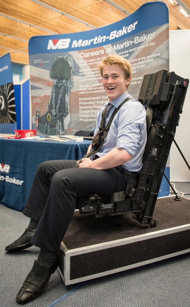 Alex Powell, IMEE finalist in a pilot ejector seat at the Martin Baker stand