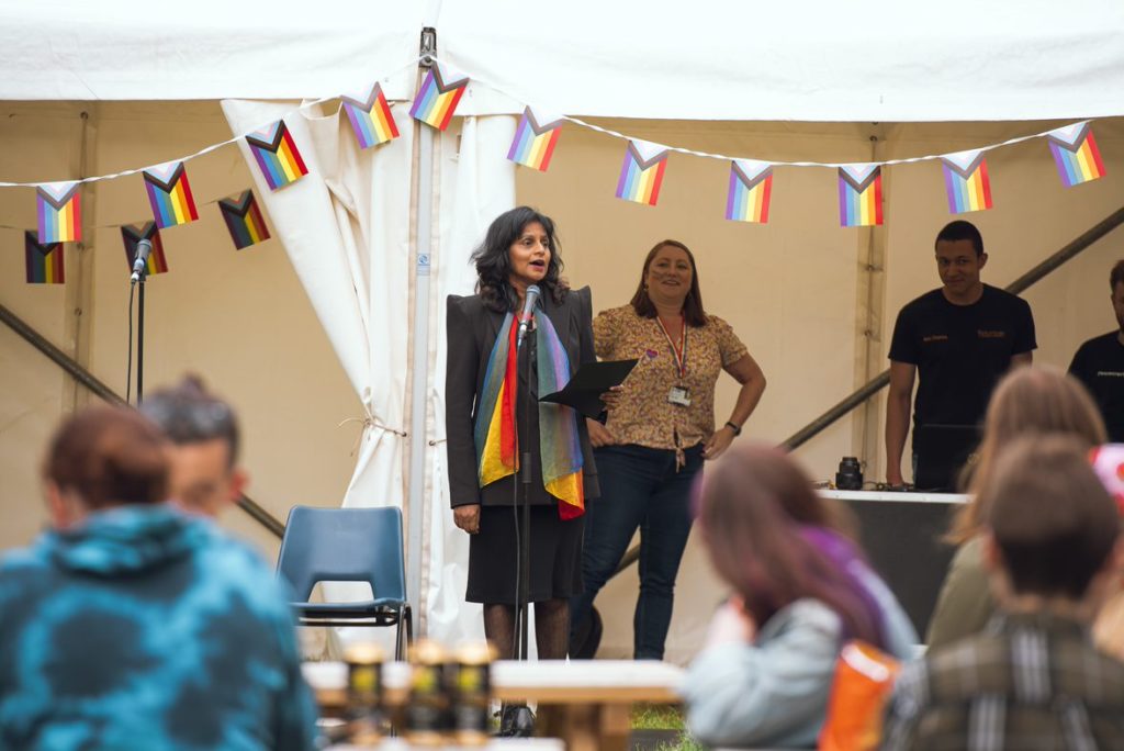 Vice-President Rajani Naidoo and Amy Birch speaking to a crowd from beneath the marquee at the Campus Pride event 2022