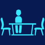 Silhouette of a person sat at an empty table.