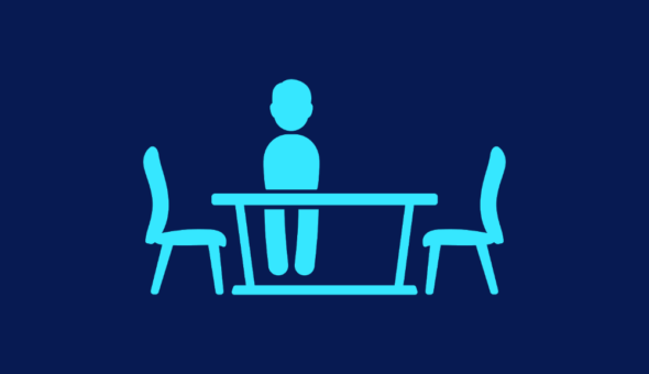 Silhouette of a person sat at an empty table.