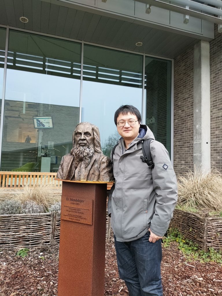 Ming Xie posing next to status