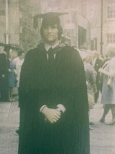 Neil Pollard at his graduation ceremony wearing a gown and mortarboard