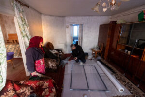 Photo of one of the charities fitting a PET window in a home in Ukraine. 