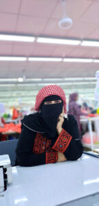 A female Syrian worker posing for the camera during an extra shift in a Jordanian garment factory 