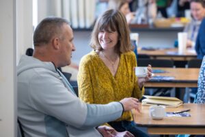 Two people sit at a table, deep in a conversation with laughter. 