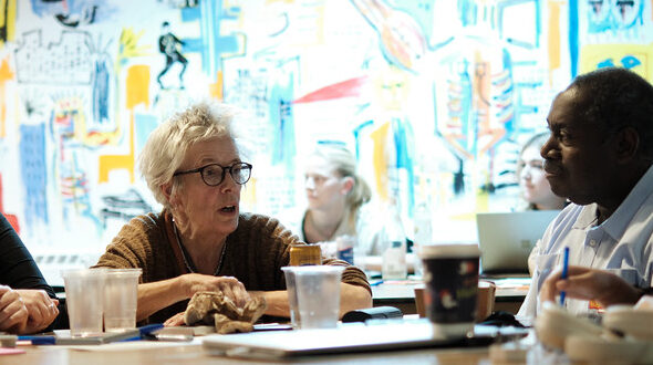 Four people in discussion around a table.