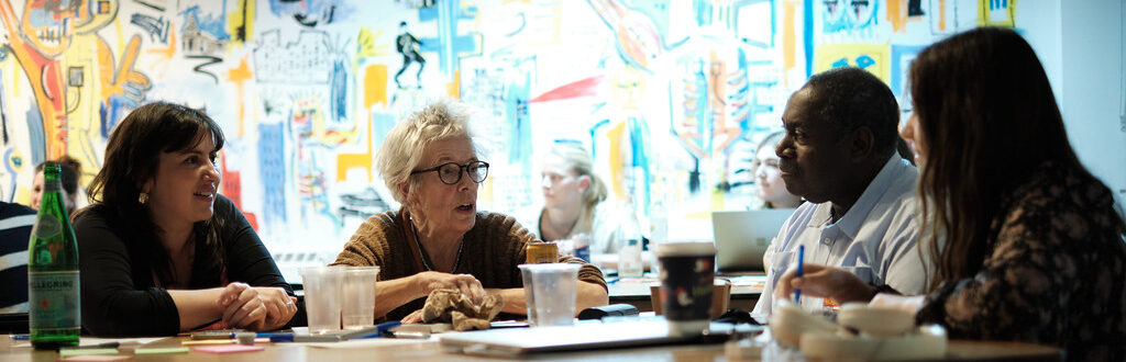 Four people in discussion around a table.