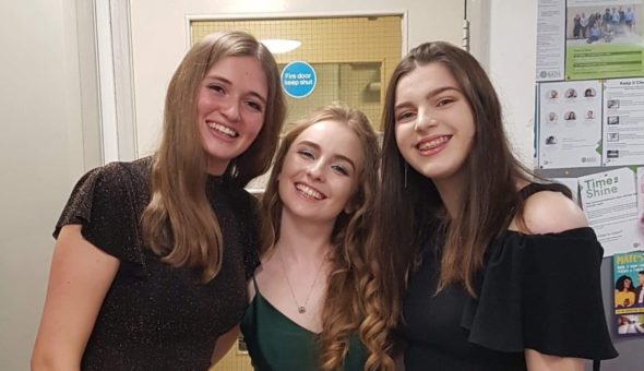 Ellie with two female friends dressed up and ready to go to the Ball