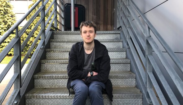 James sat at the bottom of some stone steps with hand rails either side of him