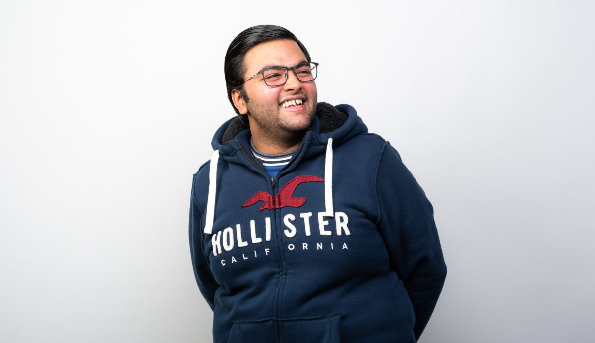 Harsh smiling at the camera wearing a navy blue sweatshirt
