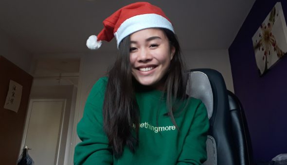 Joelle wearing a red and white Santa hat and a green sweatshirt