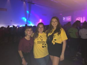 In the Freshers Week arena with my two female friends wearing our accomodation t-shirts. Mine was purple and my friends were in yellow.