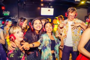 At the campus nightclub with my flatmates with red headphones on listening to music at the silent disco