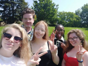 Five student, four females and one male positn for a head and shoulders photo