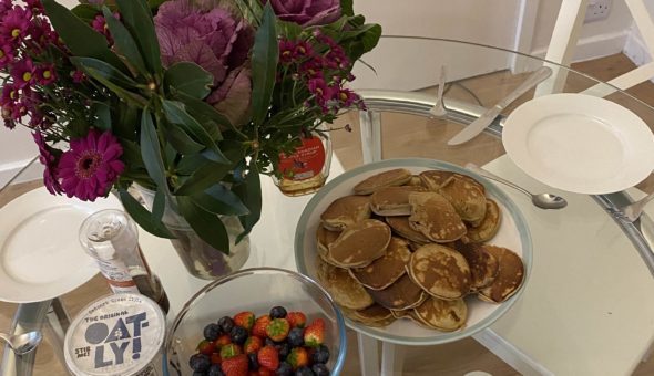 A plate of banana pancakes and berries