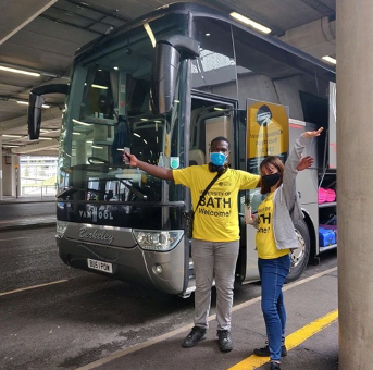 Student volunteers dressed in bright yellow in front of the coach