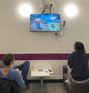 A male and a female playing Mario Kart 8 on the TV.