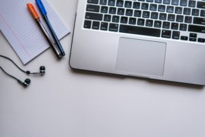 A picture of the bottom of a laptop and some pens 