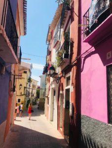 A narrow street with brightly coloured buildings.