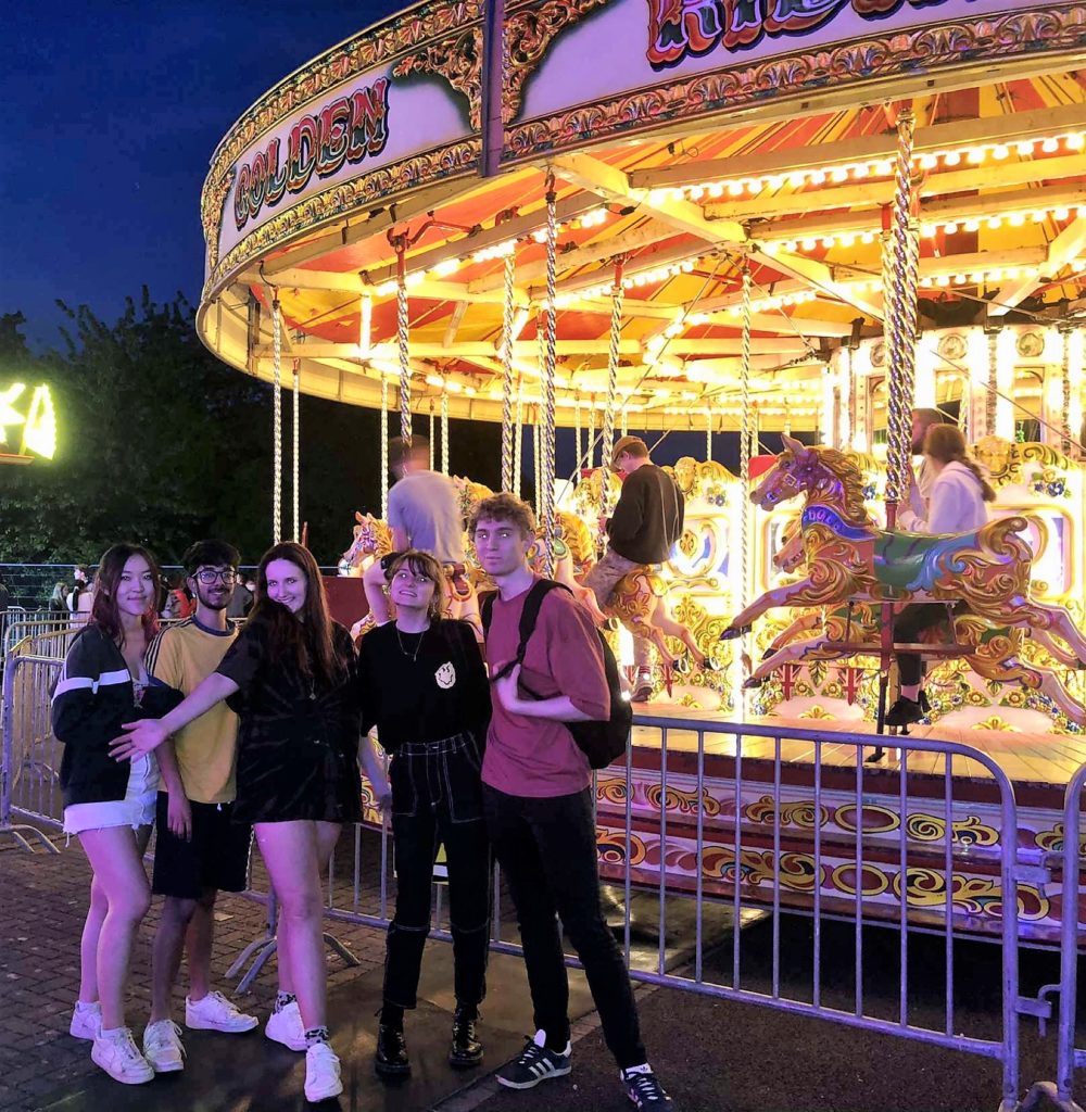 Five flatmates at a funfair on campus