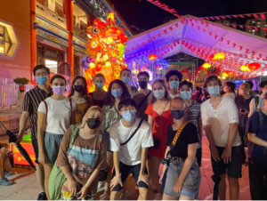 Image showing a group of students waring facemasks on a night out with a traditional canopy and decorative dragon