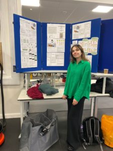 Me posing in front of a big board display of my final year project posters.