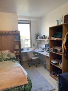 A bed, desk and chair and cupboard in student accommodation